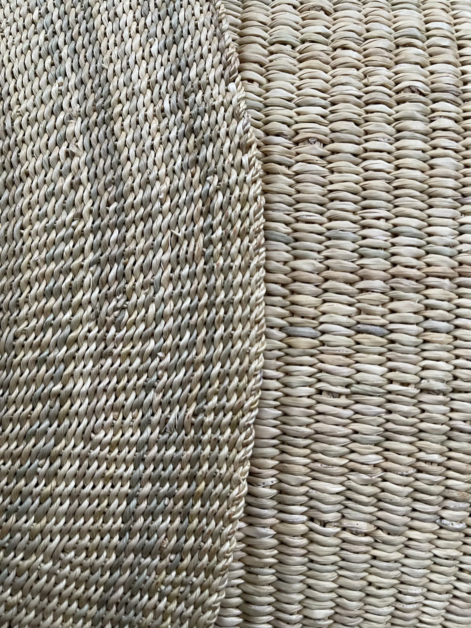 Close detail of fine straw weaving beside the larger weave of a natural-coloured basket.